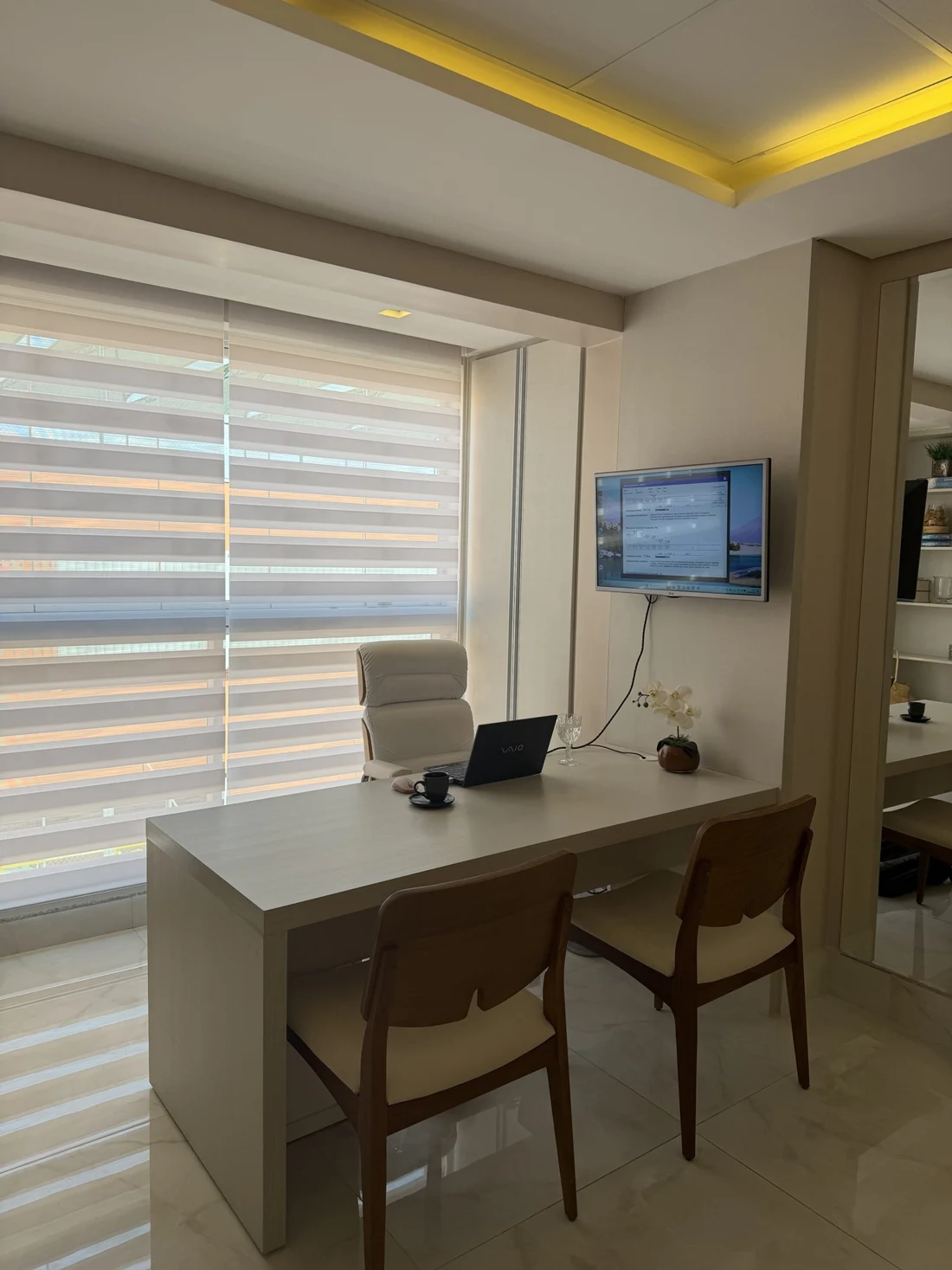 Consultório com mesa de atendimento e iluminação natural